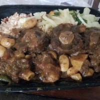 Oxtail · Served with choice of side: Rice and Peas or White Rice, Steamed Vegetables and Plantains

