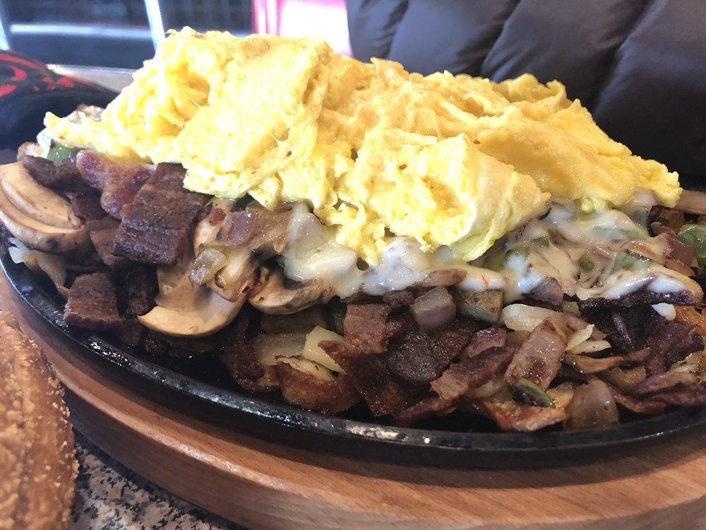 Ultimate Skillet · Bacon, sausage, mushroom, bell pepper, onion and pepper Jack cheese served on a bed of hash browns with 2 eggs on top and a side of toast.