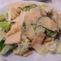 Caesar Salad · Romaine lettuce tossed in caesar dressing with large croutons. Topped with shaved Parmesan c...