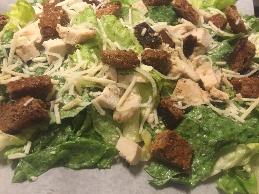Chicken Caesar Salad · Tender chunks of marinated chicken breast served over a bed of romaine lettuce tossed with creamy Caesar dressing. Topped with Parmesan cheese and homemade garlic croutons.