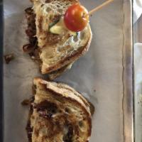 Brie and Bacon Grilled Cheese Sandwich · Gooey Brie, crispy bacon, and caramelized onions on rustic paisano.