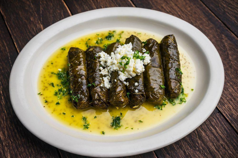 Dawali · Rolled grape leaves stuffed with rice, chickpeas, tomatoes, and parsley, topped with Aladdin's dressing, feta, and chopped parsley. Served with pita. Gluten-free and vegetarian.