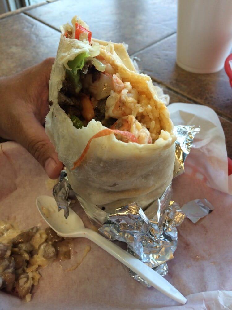 Prawn Burrito · A large flour tortilla filled with tiger prawns, bell peppers, onions, tomatoes, whole beans, rice, cheese, guacamole, and sour cream.
