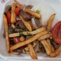 Lomo Saltado · A stir fry of beef, red onions, tomatoes, green onion, cilantro and french fries. Served wit...