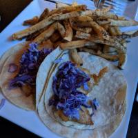 New England Fish Tacos · Beer-battered and fried haddock, house slaw, drizzled with Caribbean tartar sauce. Served at...
