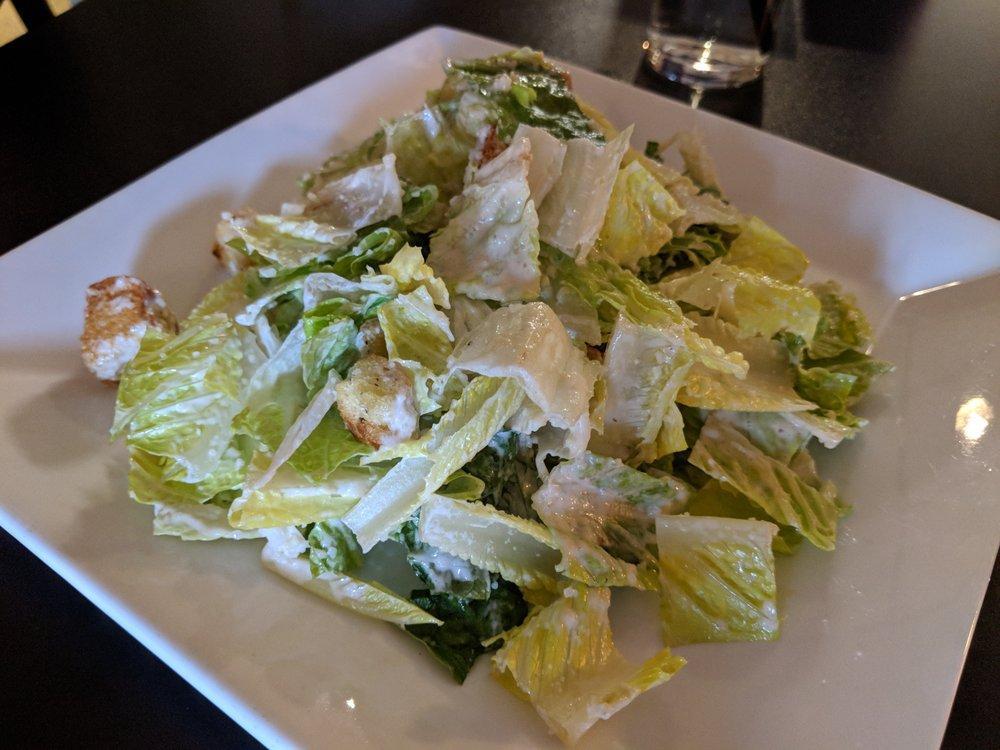Roasted Garlic Caesar Salad · Crisp romaine lettuce tossed in our roasted garlic Caesar dressing. Topped with Parmesan cheese and homemade croutons.