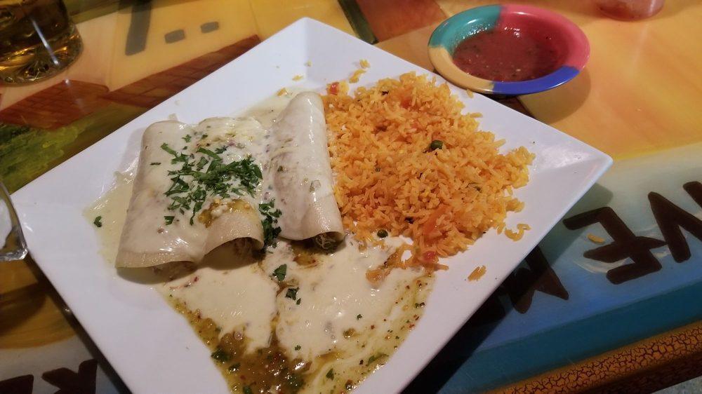 Enchiladas Suizas · 3 chicken enchiladas topped with cheese sauce, green sauce and cilantro. Served with rice.