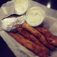 Fish and Chips · Homemade batter-dipped fish fillets served in a basket of chips with a pickle and tartar sau...