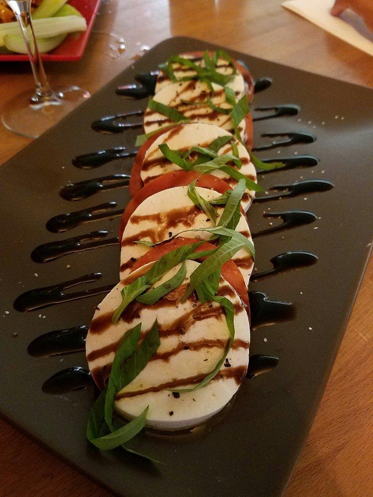 Mozzarella Caprese Salad · Beefsteak tomatoes, homemade fresh mozzarella, and basil, with balsamic glaze.