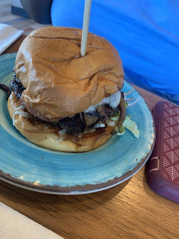 Magic Mushroom Burger · Lettuce, tomato, onion, herb mayo, garlic butter mushrooms, sherry butter onions, and swiss.
