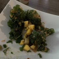 Mango Palak Chaat · Crispy spinach, mango, and drizzled with chutneys.