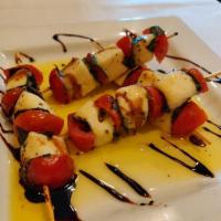 Skewered Caprese Salad · Fresh ciliegine mozzarella balls skewered with grape tomatoes and fresh basil, with extra vi...