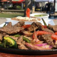 Fajitas · Seared sizzling hot with bell peppers and onions, a side of guacamole, tortillas and refried...