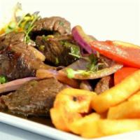 Lomo Saltado · Top tenderloin cuts sauteed with soy sauce and light vinegar, onions, and tomato wedges. Ser...