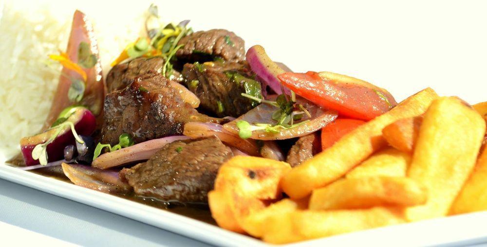 Lomo Saltado · Top tenderloin cuts sauteed with soy sauce and light vinegar, onions, and tomato wedges. Served with garlic white rice and french fries.