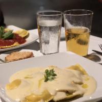 Porcini & Truffle Ravioli · Fresh pasta with porcini mushrooms and truffle topped with a creamy white wine sauce & a spl...