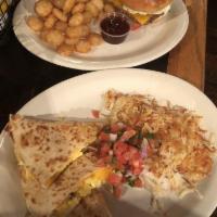 Breakfast Quesadilla · Scrambled eggs, and cheddar Jack cheese in a flour tortilla with hash browns and salsa fresca.