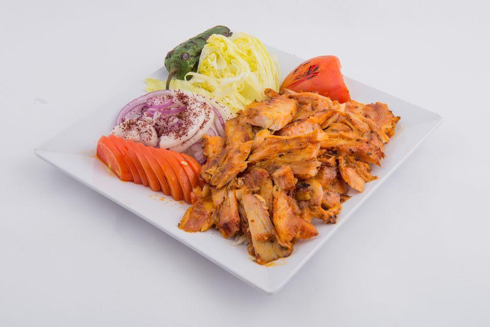 Chicken Gyro · Layers of marinated chicken breast are wrapped around a large vertical split and grilled in front of an ingenious tier of charcoal fires. Served with rice, lettuce, onions and tomatoes.