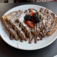 Nutella French Toast · Nutella, whole grain bread, topped with seasonal berries and powdered sugar.
