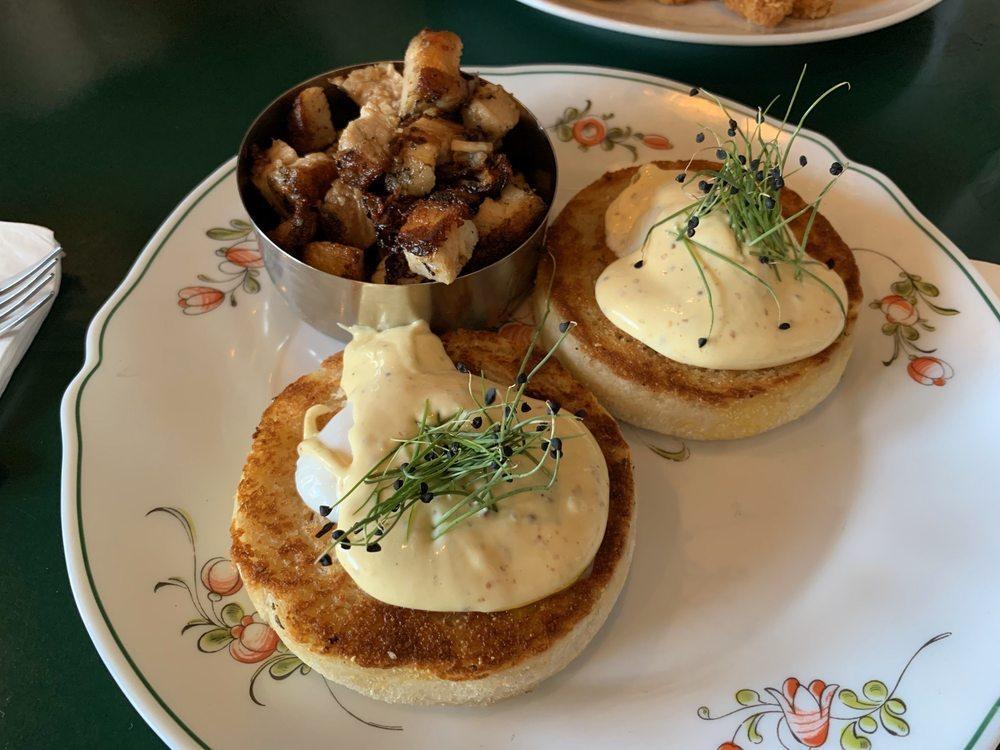 Eggs Benedict · Oven-roasted house-made pork porchetta served on 2 toasted English muffin halves each topped with a sous vide egg and roasted garlic hollandaise. 