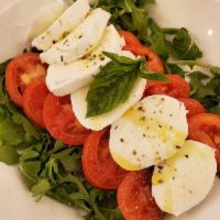 Caprese Salad · Tomato, arugula, Buffalo mozzarella, olive oil, green and black olives, oregano.