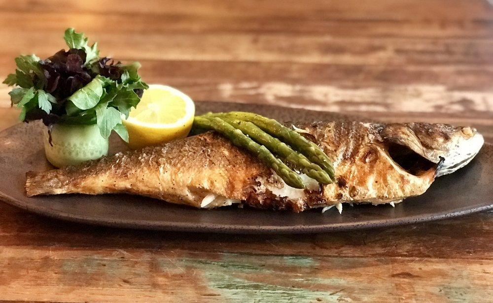 Branzino · Chargrilled whole branzino served with lemon, asparagus and bouquet greens.