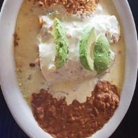 Chicken Avocado Enchiladas · Tender chicken enchiladas topped with sour cream cheese sauce and fresh avocado slices. Serv...