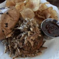 Pulled Pork Sandwich · Pulled pork sandwich served with a side of honey bourbon BBQ sauce and fried onion straws.
