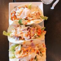 Korean Tacos · Choice of meat over 3 warm flour tortillas filled with crisp lettuce and coleslaw, topped wi...