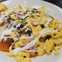 Chilaquiles · Corn tortilla chips covered with sauce and melted Jack cheese. Topped with red onions and a ...