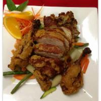 Tamarind Duck · Crispy duck served with steamed vegetables topped with tamarind sauce.
