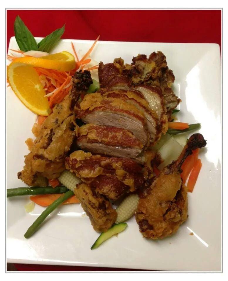 Tamarind Duck · Crispy duck served with steamed vegetables topped with tamarind sauce.