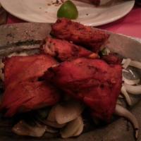 Tandoori Chicken · Fresh chicken marinated in spiced yogurt and roasted in a tandoori oven. Served with rice an...