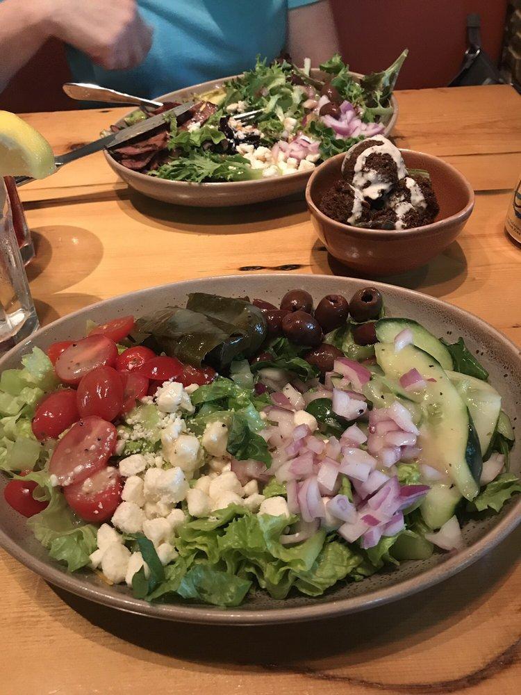 Greek Salad · Romaine, grape tomatoes, cucumbers, red onions, topped with feta, Kalamata olives and stuffed grape leaves, Lemon Vinaigrette. (GF)