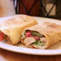 Chicken Shawarma Sandwich · Marinated, charbroiled halal chicken wrapped in pita with romaine, tomato, yogurt garlic sau...