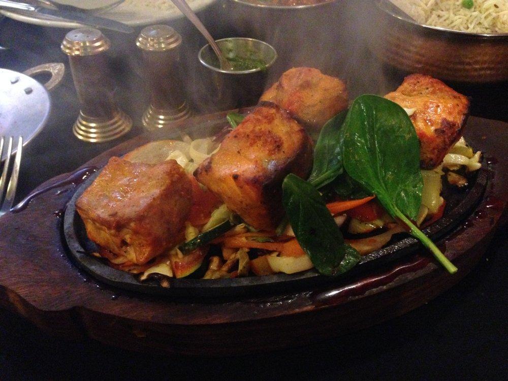 Salmon Tandoori · Salmon marinated in yogurt and spices, broiled in the tandoor oven and served sizzling with sauteed onions, bell peppers, cabbage and carrots.