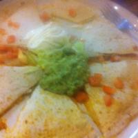 Quesadilla · Flour tortilla with melted cheese with guacamole, sour cream, lettuce and tomato on top.