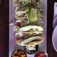 Fish Tacos · Housemade coleslaw, avocado, chipotle lime-cilantro cream sauce, and a dash of Cotija cheese.