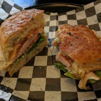 Turkey Focaccia · Smoked turkey breast and bacon with Gouda cheese, forest greens, tomato, and basil aioli.