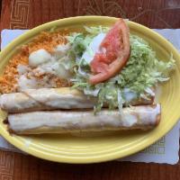 Flautas · 2 flautas, 1 with chicken and 1 with shredded beef, served over a bed of Spanish rice, cover...