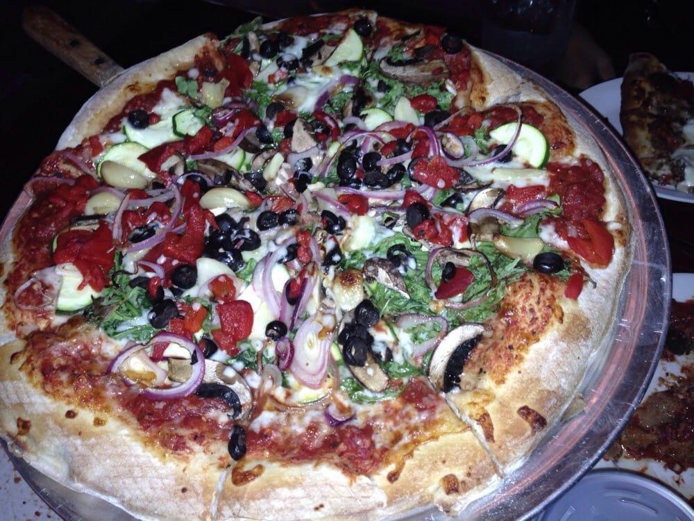 Veggie Pizza · Arugula, portabella mushrooms, roasted garlic, zucchini, red onions, black olives, and roasted red peppers.