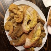 Seafood Platter · Golden fried catfish, gulf shrimp & oysters on a bed of house cut french fries.
