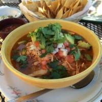 Tortilla Soup · A delicious soup broth with grilled chicken, avocados and green onions, topped with crispy t...
