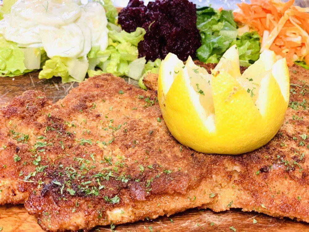 Chicken Schnitzel · Breaded chicken breast served with side of cabbage, cucumber and beet salad.