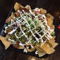 Nachos Supreme · Tortilla chips topped with our three bean chili, cheese, jalapeno, black olives, lettuce, pi...