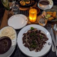 Vaca Frita · Crispy shredded ﬂank steak, onion, garlic, parsley, sour orange. Served with white rice and ...
