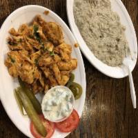 Chicken Shawarma · Boneless chicken marinated in lemon, yogurt, house spices and ground. Served with pickles an...
