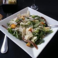 Caesar Salad · Crisp romaine lettuce with homemade croutons and fresh shaved Parmesan cheese tossed in a cl...