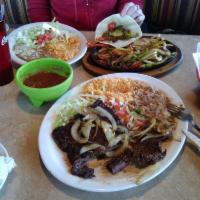 Carne Asada · Skirt Steak topped with grilled onions. Served with rice, beans, lettuce, pico de gallo and ...