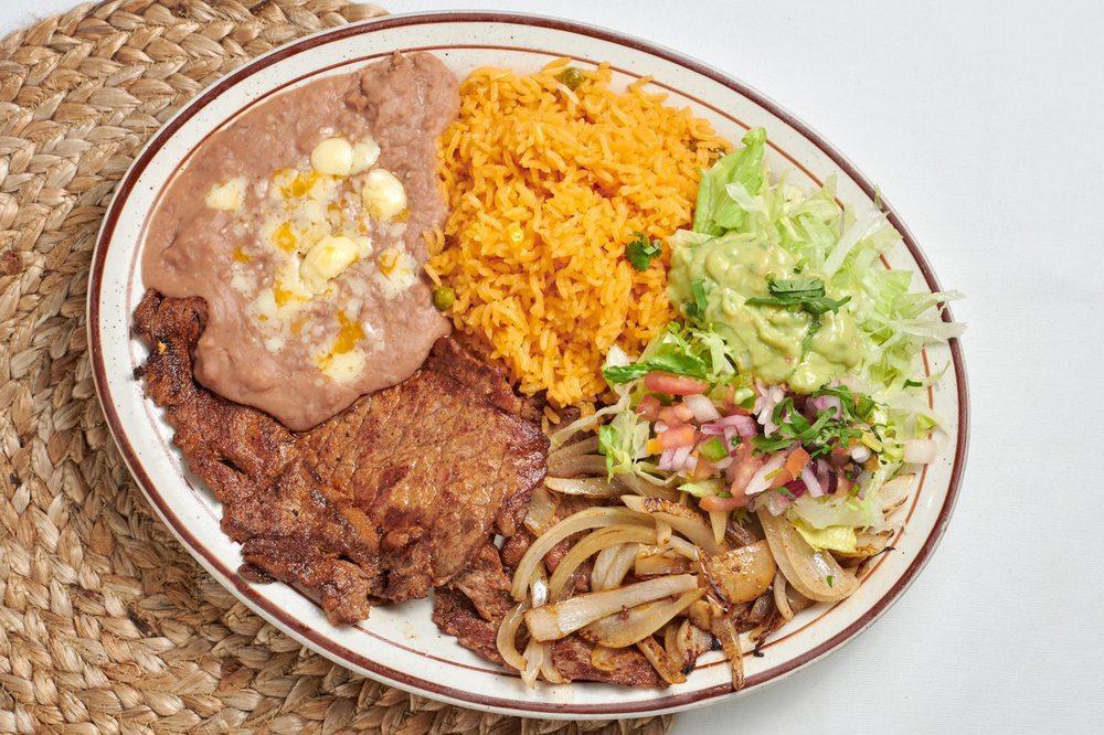 Carne Asada · Thinly sliced ribeye steak with grilled onions. Served with rice, beans, tortillas, and guacamole salad.